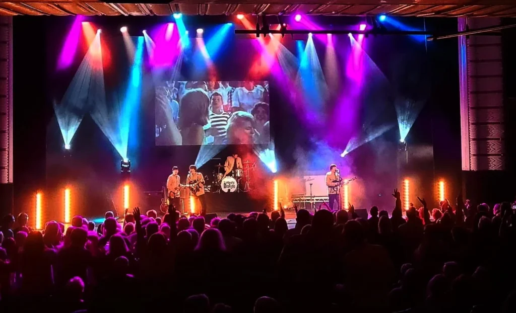 Truss rig flown over a live band stage with moving lights